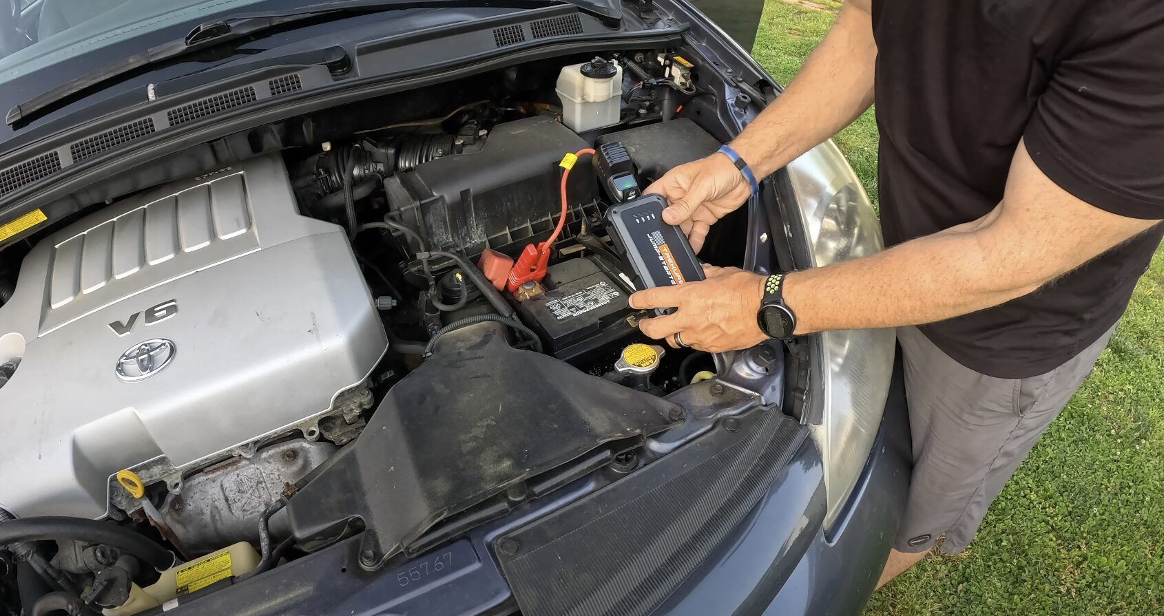Professional technician jump starting car battery